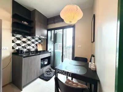 Modern kitchen with open layout and stylish backsplash in compact apartment.