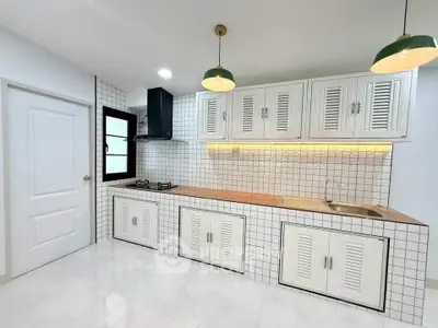 Modern kitchen with sleek white cabinetry and gas stove in stylish apartment.