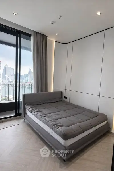 Modern bedroom with city view and large balcony access in luxury apartment