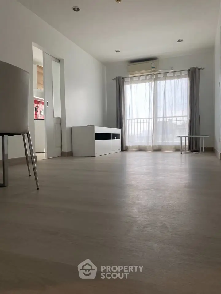 Spacious minimalist living room with large window and natural light