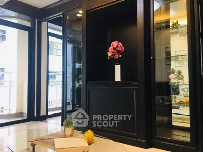 Elegant living room with glass cabinets and balcony view, perfect for modern urban living.