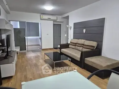 Modern living room with sleek furniture and wooden flooring, perfect for cozy gatherings.