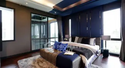 Luxurious modern bedroom with elegant decor and large windows offering natural light.