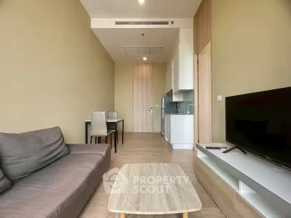 Modern living room with sleek furniture and open kitchen layout in a stylish apartment.