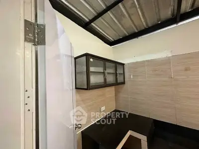 Compact kitchen with modern cabinetry and sleek countertops in a cozy real estate unit.