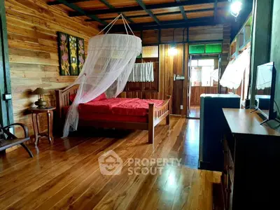 Charming rustic bedroom with wooden decor and mosquito netting, perfect for a cozy retreat.