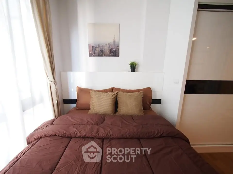 Cozy bedroom with modern decor and natural light in a stylish apartment.