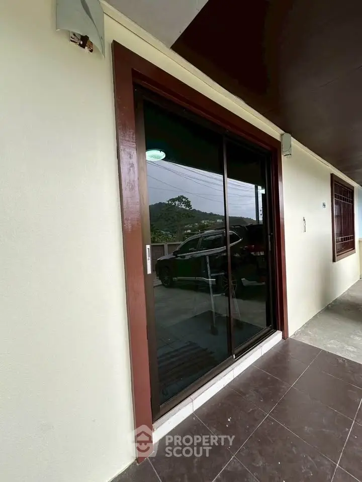 Modern sliding glass door entrance with tiled flooring and outdoor view.