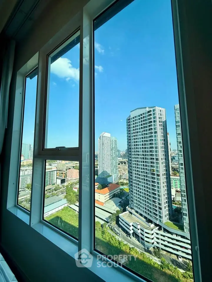 Stunning cityscape view from a high-rise apartment window, showcasing modern urban living.