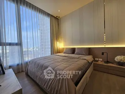 Luxurious bedroom with floor-to-ceiling windows and modern decor in high-rise apartment.