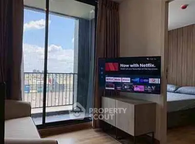 Modern living room with balcony view and smart TV in a stylish apartment.