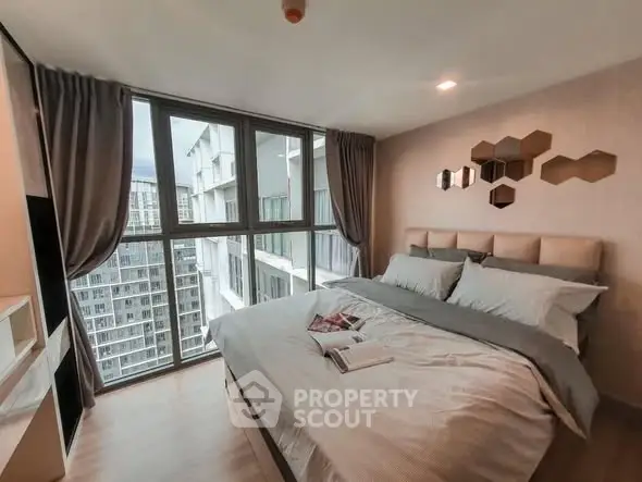 Modern bedroom with large windows and stylish decor in a high-rise apartment.