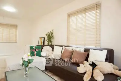 Cozy living room with plush sofa and decorative pillows, perfect for relaxation.