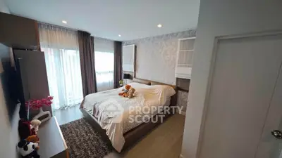 Spacious modern bedroom with elegant decor and large windows for natural light.
