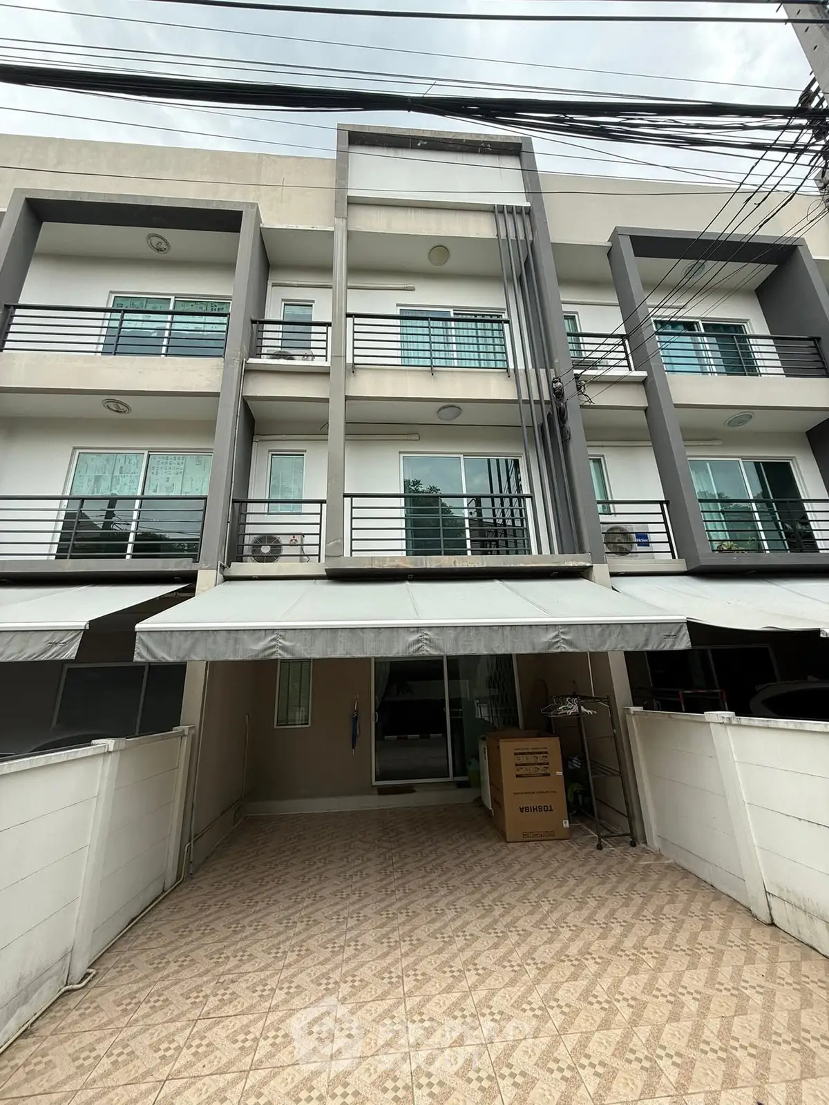 Modern multi-story townhouse with spacious driveway and contemporary design.