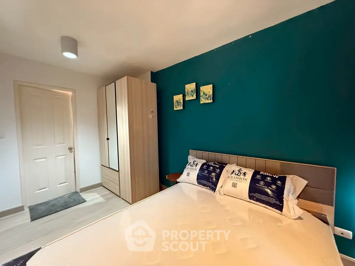 Modern bedroom with teal accent wall and stylish wardrobe