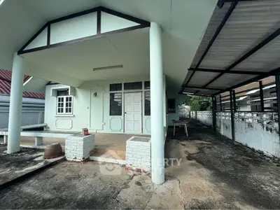 Charming single-story home with covered porch and carport, ideal for cozy living.