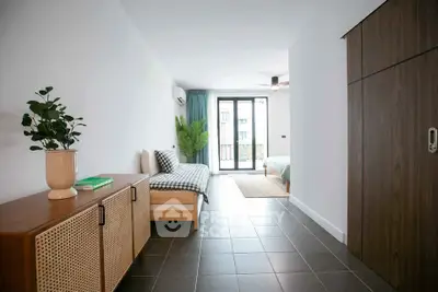 Spacious modern apartment with open layout and stylish decor, featuring a cozy living area and large windows.