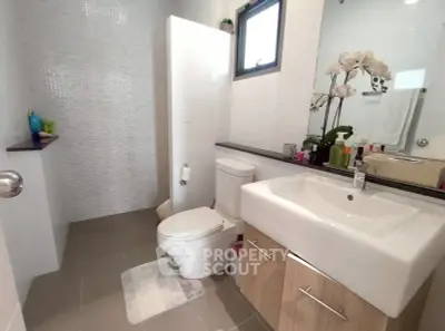 Modern bathroom with sleek fixtures and natural light, featuring a stylish vanity and contemporary design.