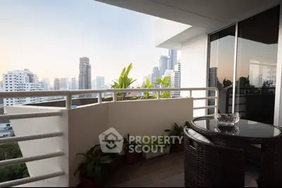 Modern balcony with city skyline view and stylish outdoor furniture.