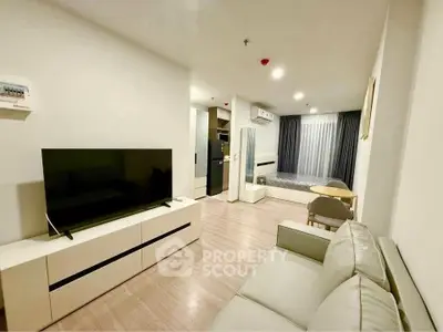 Modern living room with sleek furniture and large TV, open layout design.