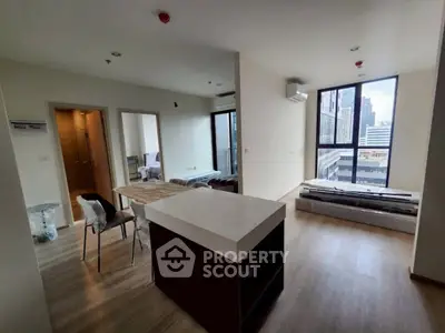 Modern open-plan living area with city view, featuring sleek furniture and abundant natural light.