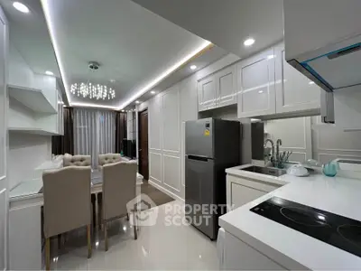 Modern kitchen with sleek design, featuring dining area and stainless steel appliances in a stylish apartment.