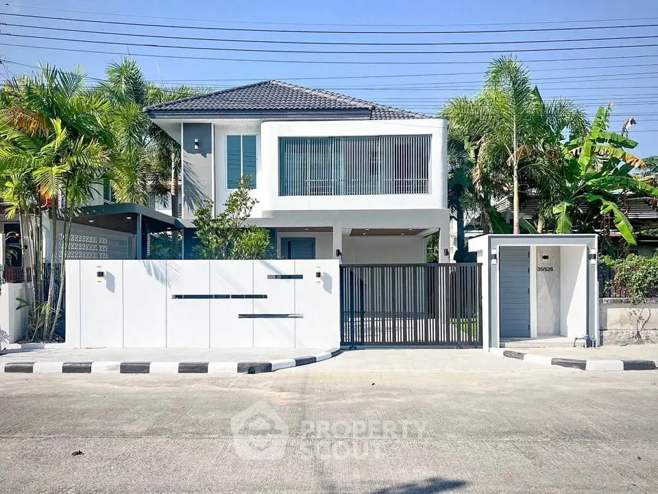 Modern two-story house with sleek design and lush greenery