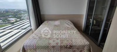 Cozy bedroom with large window offering panoramic city views and stylish decor.