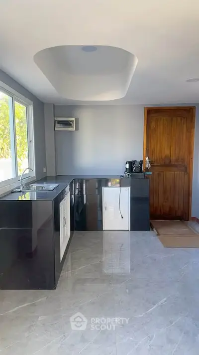 Modern kitchen with sleek black countertops and large window view