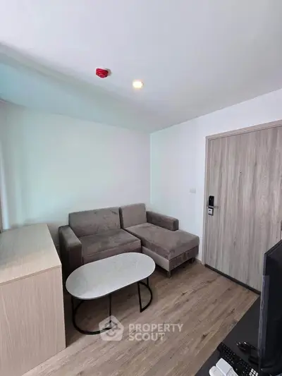 Modern living room with sleek furniture and wooden flooring in a cozy apartment.