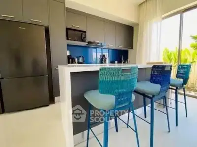 Modern kitchen with sleek cabinetry, island seating, and large window for natural light.