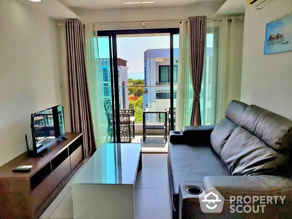 Modern living room with balcony view, sleek furniture, and abundant natural light.