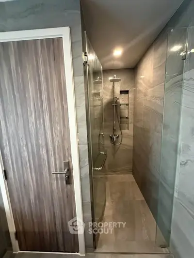 Modern bathroom with sleek glass shower and wooden door