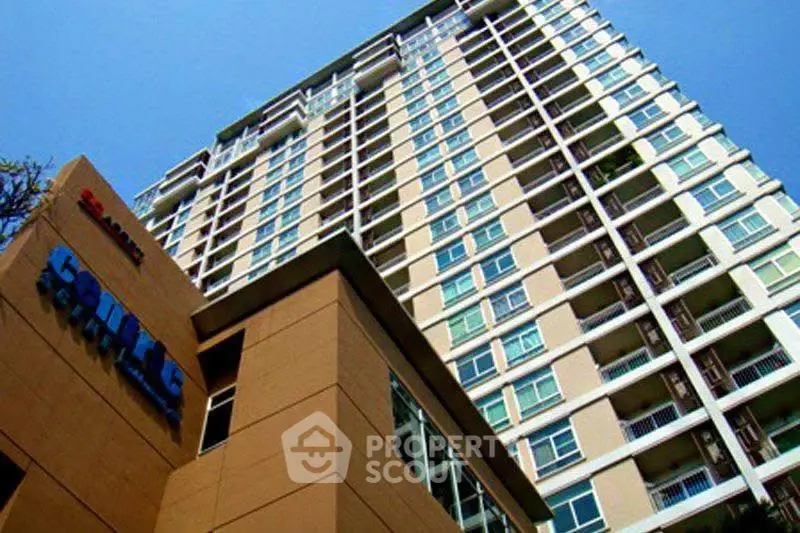 Modern high-rise building with sleek architecture and numerous balconies.