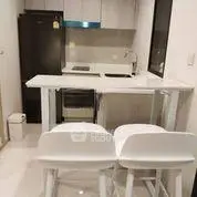 Modern compact kitchen with breakfast bar and sleek appliances in a cozy apartment.