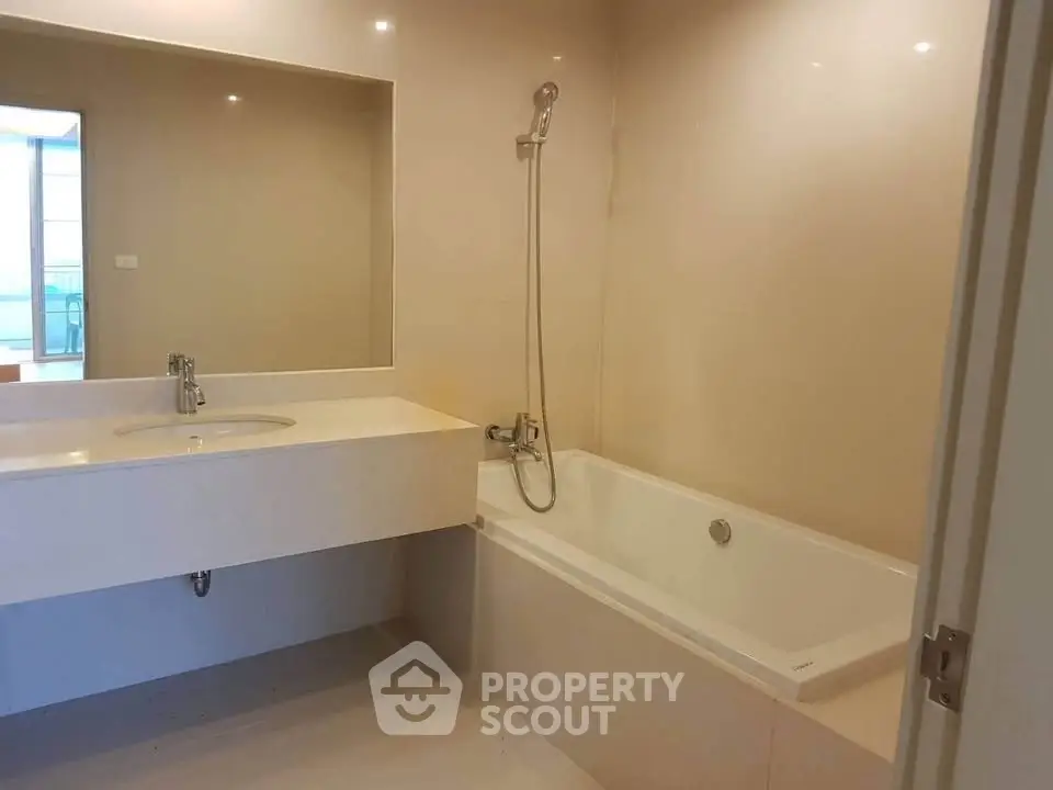 Modern bathroom with sleek design featuring a bathtub and large mirror, perfect for relaxation.