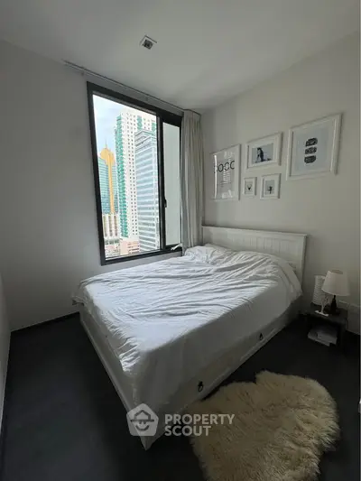 Modern bedroom with city view, featuring a cozy bed and stylish decor.