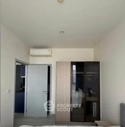 Modern bedroom with sleek wardrobe and air conditioning in a stylish apartment.