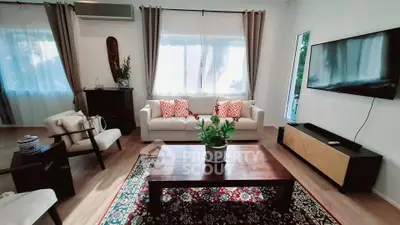 Charming living room with modern decor, featuring a cozy sofa, stylish coffee table, and wall-mounted TV.