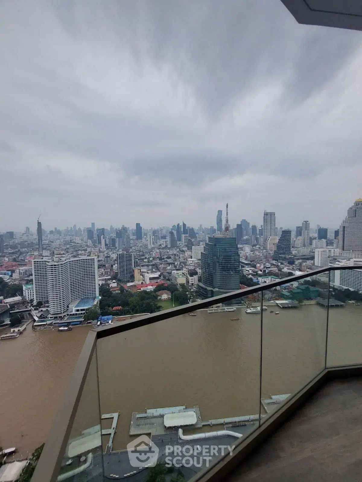 Stunning cityscape view from a high-rise balcony overlooking a river and skyline.