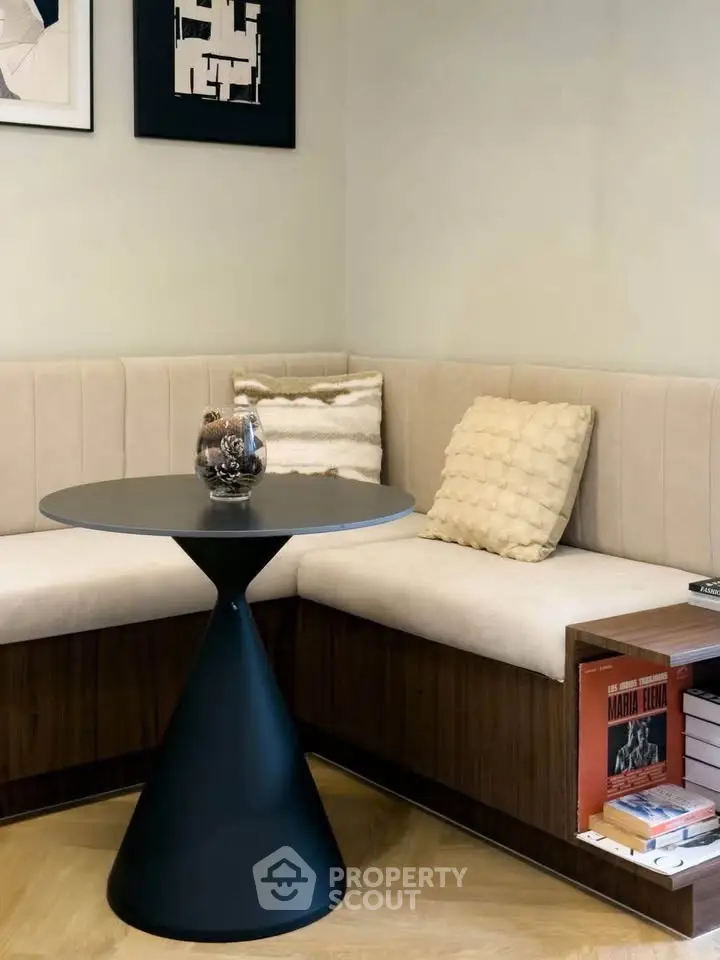 Stylish modern living room corner with chic round table and cozy seating.