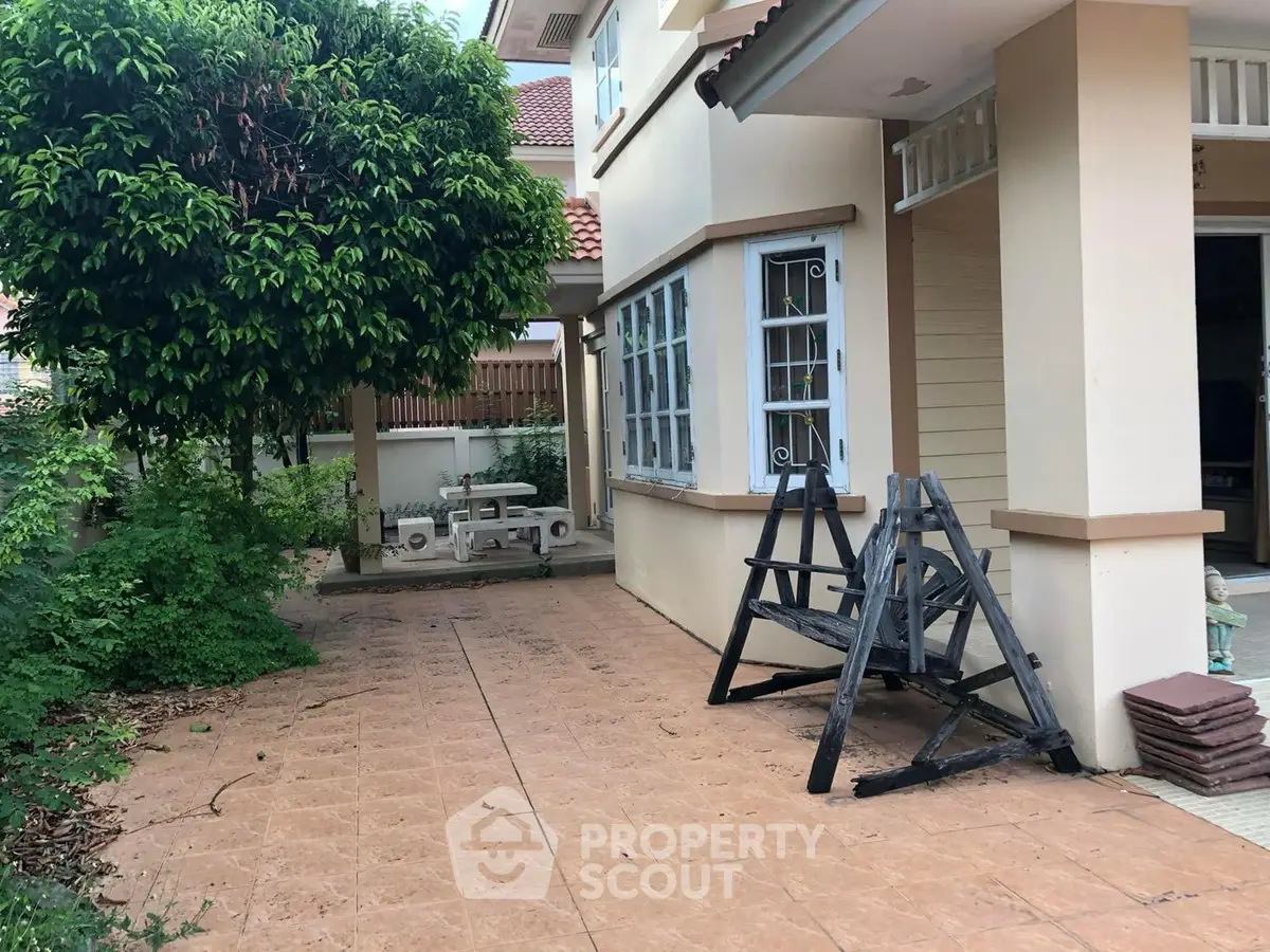 Charming suburban home with spacious garden and tiled patio, perfect for outdoor relaxation.