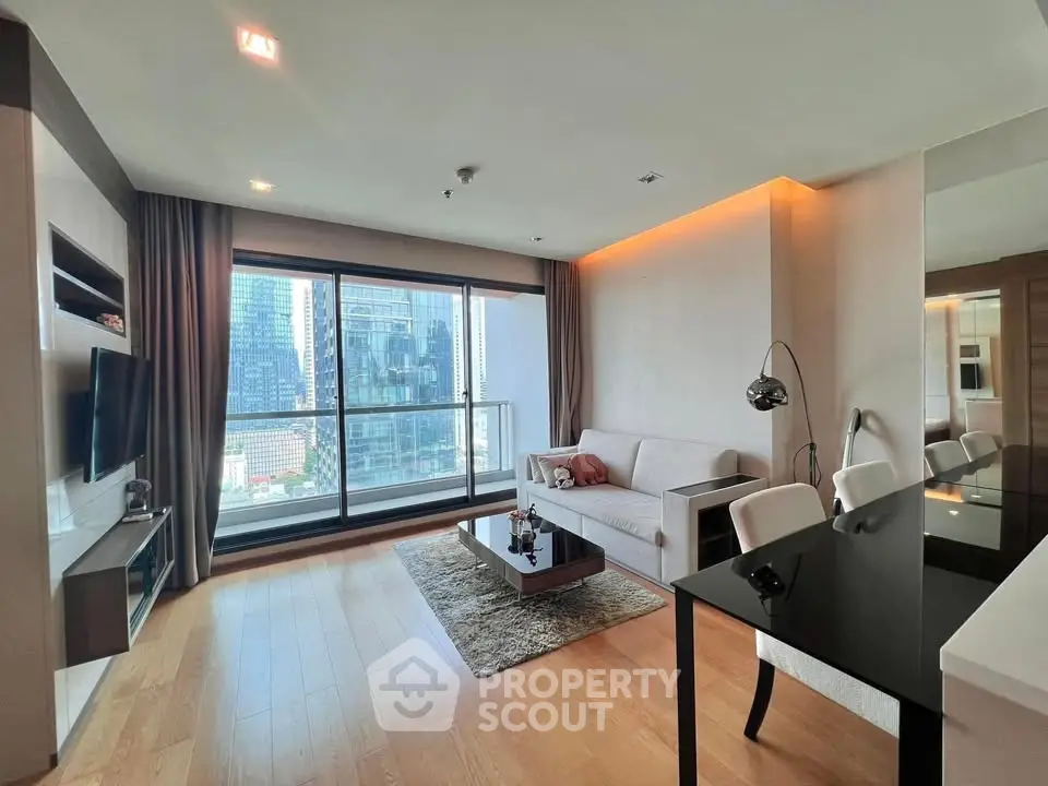 Modern living room with city view, elegant decor, and ample natural light.