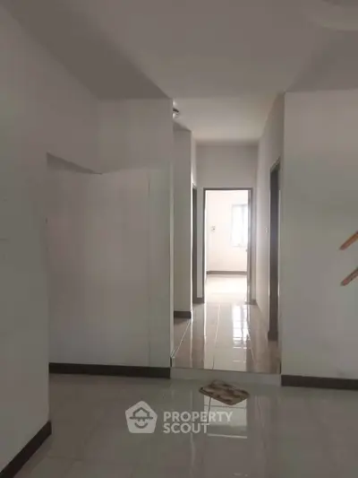 Spacious hallway with tiled flooring and natural light in modern home