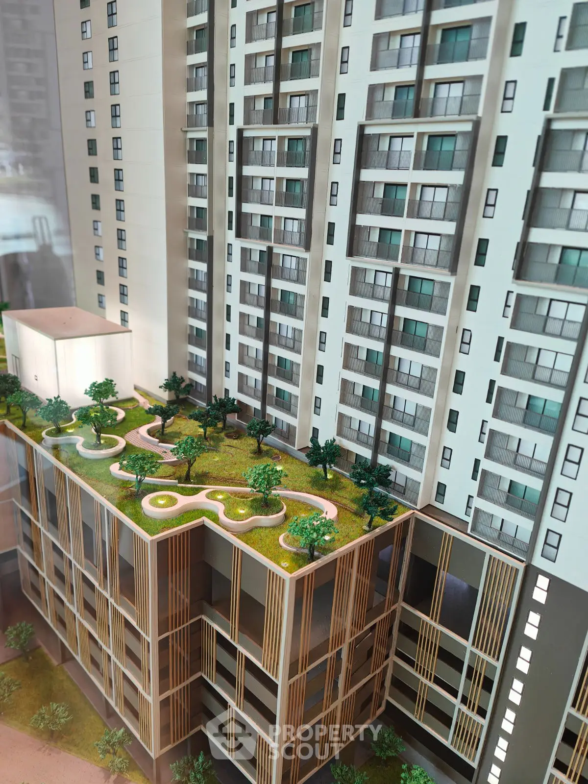 Modern high-rise building with lush rooftop garden and sleek architectural design.