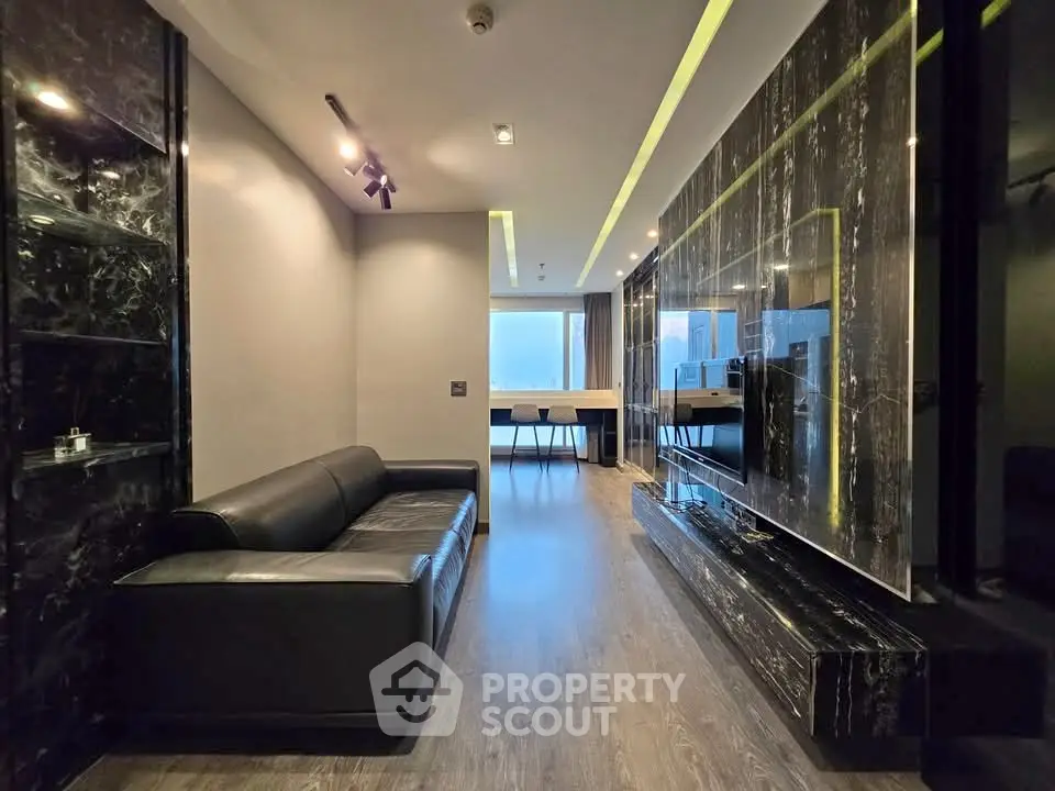 Luxurious modern living room with sleek black marble accents and stylish lighting.