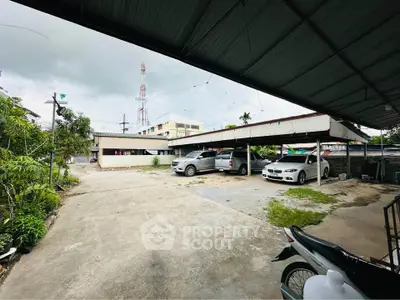 Spacious parking area with multiple cars and covered parking, ideal for residential or commercial use.