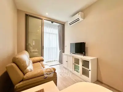 Modern living room with leather sofa and TV, featuring a sliding glass door leading to a balcony.
