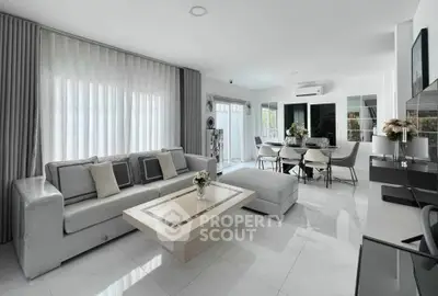 Modern living room with elegant decor and spacious dining area, featuring sleek furniture and abundant natural light.